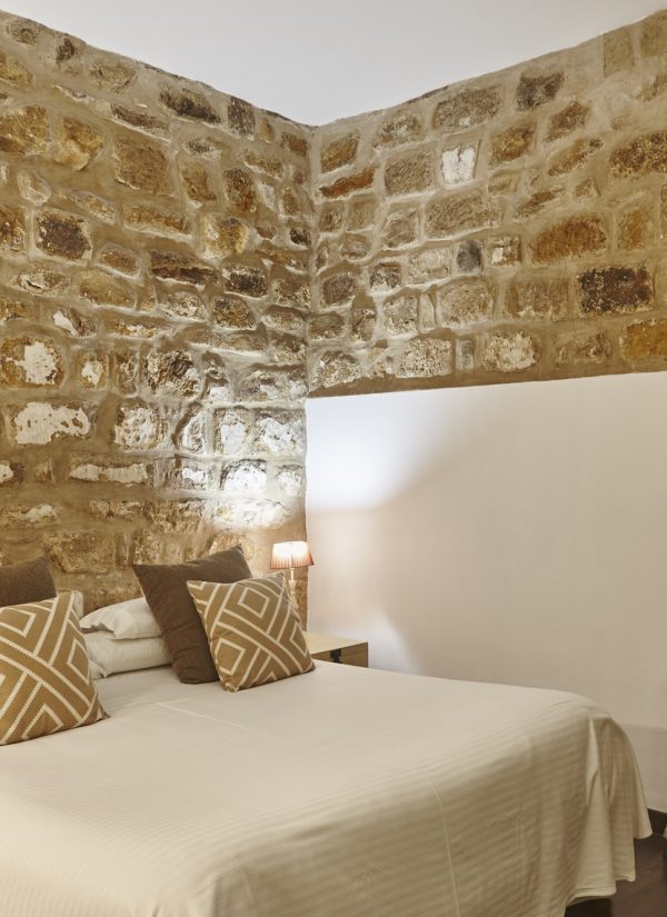 Bedroom with stone walls. Comfortable modern hotel room. Interior architecture